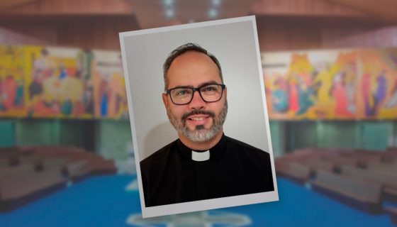 Imagem do novo vigário paroquial, Pe. Eduardo Gavioli, sorrindo e vestindo paramentos litúrgicos, simbolizando sua acolhida pela comunidade local.